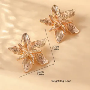 Primo piano di eleganti orecchini a forma di fiore dorato 3D con dettagli metallici raffinati.