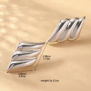 Primo piano di orecchini metallici a strati che mostrano dimensioni precise e peso leggero.