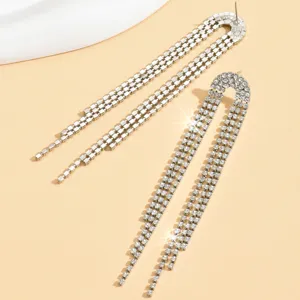 Primo piano di lunghi orecchini con frange di cristallo, strass scintillanti e design a U.