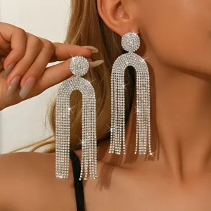 Dettaglio di lussuosi orecchini lunghi con frange di strass, gioielli scintillanti ed eleganti.