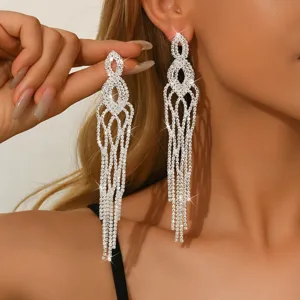Primo piano di orecchini lunghi e scintillanti con strass e design a frange di cristallo.