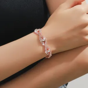 Dettaglio di bracciale intrecciato con strass in oro rosa, elegante gioiello per donne.