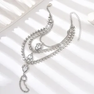 Dettaglio catena da piede multistrato con strass, elegante cavigliera di cristallo.