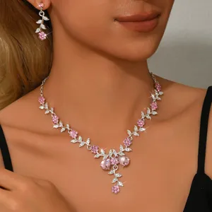Primo piano dettaglio della collana e degli orecchini eleganti in cristallo e foglie d'argento.