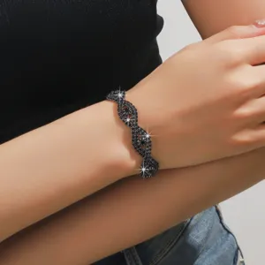 Dettaglio squisito del bracciale in strass nero intrecciato, gioiello scintillante da polso.
