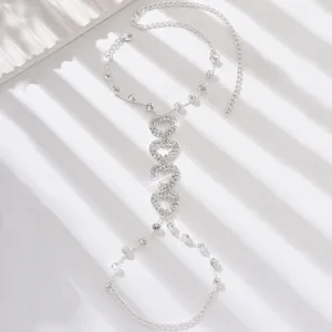 Close-up of sparkling rhinestone crystal heart hand chain detail on white textured surface.