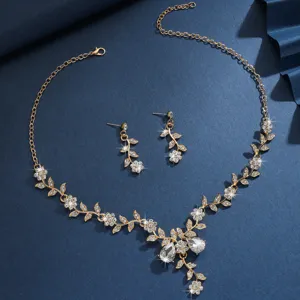 Set collana e orecchini da sposa foglie strass oro, elegante gioielleria nuziale vista dettagliata.
