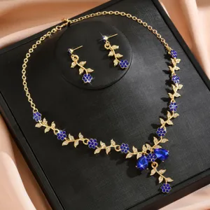 Set collana e orecchini da sposa con fiori in cristallo blu e finitura dorata per eventi eleganti.