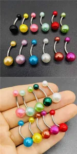 Colorful acrylic belly button ring detail close-up stainless steel navel piercing jewelry.