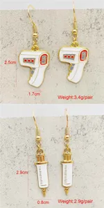 Detailed view of creative medical themed alloy earrings showing thermometer and syringe designs.