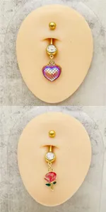 Vista detallada de piercing para ombligo de acero dorado con circonita y colgantes.