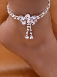 Detailed macro view of a sparkling rhinestone crystal butterfly chain on foot.