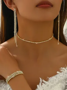 Close-up of sparkling rhinestone choker necklace, tassel earrings and multi-row bracelet set.