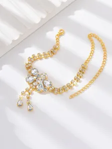 Close-up detail of a glamorous gold rhinestone dragonfly ankle chain, sparkling beach jewelry.