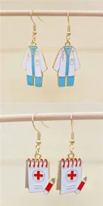 Close-up detail of medical theme doctor coat and notepad enamel dangle earrings for nurses.