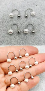 Vue détaillée de boucles d'oreilles minimalistes en acier titane avec perles et billes.