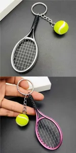 Close-up detail view of metal tennis racket keychain featuring a cute mini plush tennis ball.