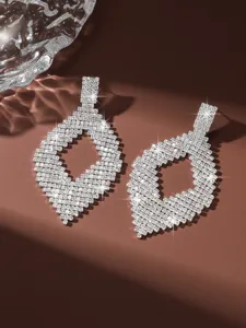Primo piano dettagliato di orecchini geometrici in strass scintillanti con grande eleganza.