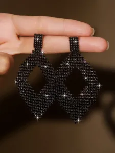 Orecchini pendenti in strass nero con elegante design geometrico traforato e brillante.