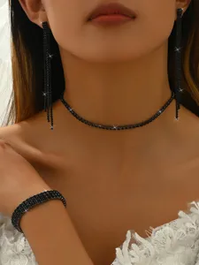 Black rhinestone jewelry detail shot featuring sparkling claw chain earrings choker and bracelet