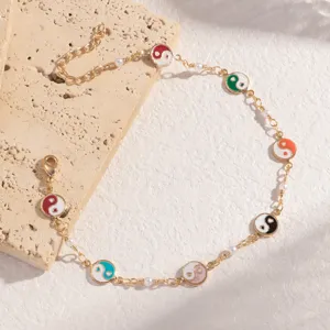 Hauptansicht eines goldenen Kettenarmbands mit bunten Yin-Yang-Anhängern und süßen Perlenakzenten.