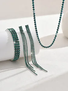 Close-up detail of emerald green rhinestone claw chain jewelry set sparkle design.