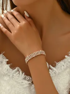 Detailed shot of a multi-row sparkling rhinestone tennis bracelet with rose gold tone setting.