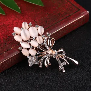 Close-up detail of exquisite rose gold cat eye stone bouquet brooch with sparkling rhinestones.