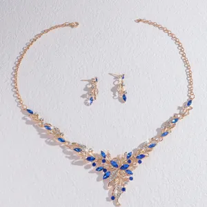 Detalle en primer plano del conjunto de collar y pendientes dorados con piedras de cristal.