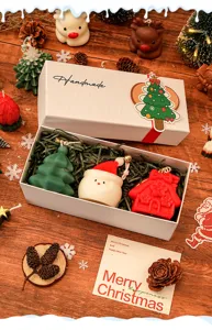 Vue détaillée de bougies parfumées de Noël faites main en forme de Père Noël et de sapin