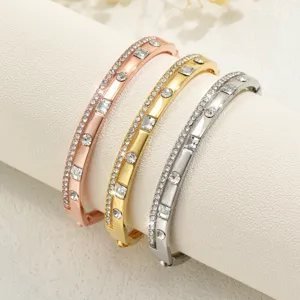 Dettaglio di squisiti bracciali metallici geometrici con strass in oro rosa, oro e argento.