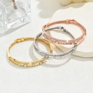 Primo piano dettagliato di tre eleganti bracciali geometrici in metallo con strass.