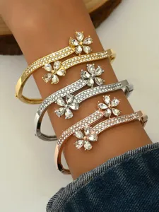 Detail shot of rhinestone flower cuff bracelets showcasing gold silver and rose gold finishes.