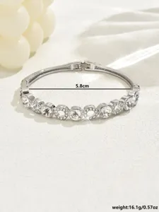 Vista dettagliata del bracciale rigido geometrico in strass argentato con cristalli luminosi.