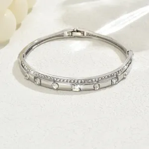 Primo piano di un braccialetto geometrico in argento con strass scintillanti, design elegante.