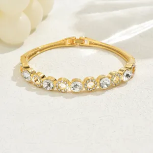 Dettaglio di bracciale rigido geometrico in strass dorato squisito, gioiello di lusso.
