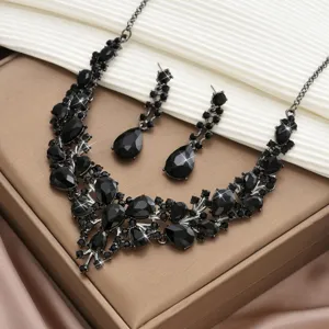 Vue détaillée de l'ensemble de bijoux collier et boucles d'oreilles en strass noir.