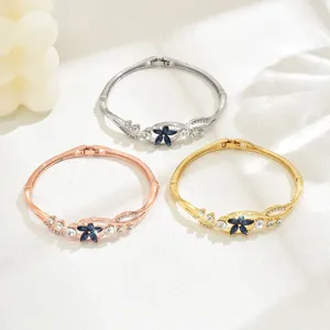 Close-up detail of three elegant floral hinged bangles in silver, rose gold, and gold finishes.