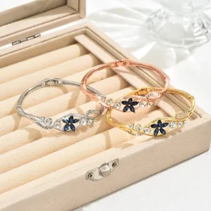 Elegant silver, rose gold, and gold hinged bangles featuring blue floral crystal rhinestones.