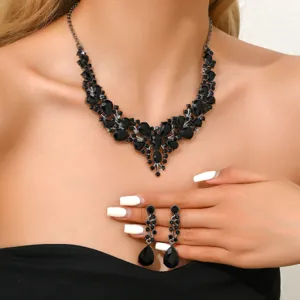 Gros plan detail de ensemble de bijoux collier statement et boucles oreillons strass cristal noir.
