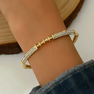 Primo piano del bracciale rigido geometrico dorato con strass, design elegante con cristalli.