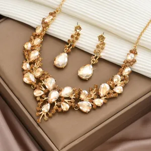 Vue détaillée de l'élégant collier de strass en cristal doré et des boucles d'oreilles.