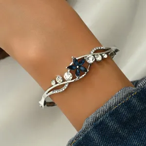 Silver rhinestone flower cuff bracelet detail, sparkling blue crystal elegant jewelry for women.