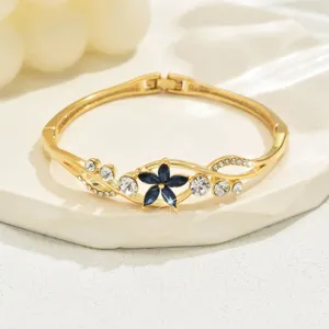 Gold tone floral hinge bracelet for women, sparkling blue and clear crystal rhinestones jewelry.