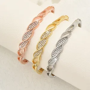 Set di bracciali rigidi geometrici in strass, dettaglio di gioielli metallici eleganti.