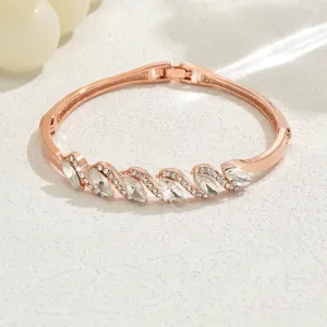 Elegante bracciale rigido in oro rosa con cristalli scintillanti e dettagli di strass.
