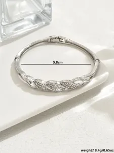 Squisito bracciale rigido geometrico in strass argentato con dettagli di cristalli scintillanti.
