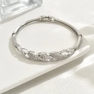 Primo piano dettagliato di un bracciale rigido geometrico in strass argento, elegante e luminoso.