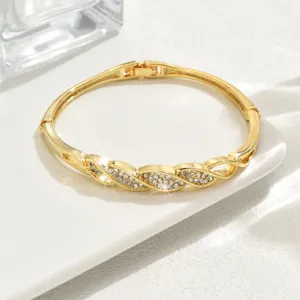 Bracciale rigido geometrico in oro con pavé di strass, dettaglio di gioielli di lusso cavi.