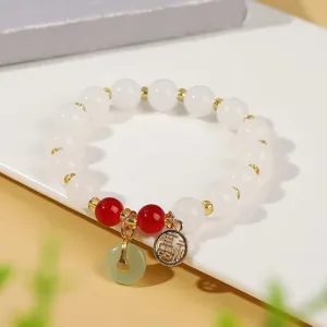 Dettaglio bracciale di perle in finta giada bianca stile cinese, gioielli con ciondolo.
